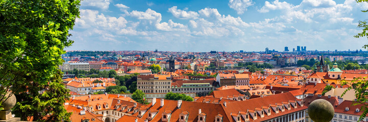 Fototapeta na wymiar Prague red roofs and dozen spires of historical Old Town of Prague. Cityscape of Prague on a sunny day. Red rooftops, spires and the Charles Bridge and Vltava River in the background. Prague, Czechia.