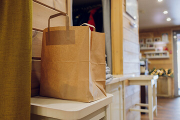 Fototapeta na wymiar dessert paper bag waiting for customer on counter in modern cafe coffee shop, food delivery, cafe restaurant, takeaway food.