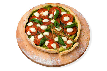 Whole Italian Pizza in Caprese salad style with sliced tomatoes, mozzarella cheese, pesto sauce served with fresh basil leaves on wooden plate served with culinary flour and spices, isolated on white 