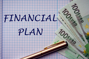 Hand written FINANCIAL PLAN on checkered sheet paper with euro banknotes next