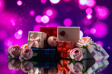 Boxes with gifts lie on the table next to flowers on a blurred background. Gifts for the holiday. Gifts for Valentine's Day. International Women's Day. Love.