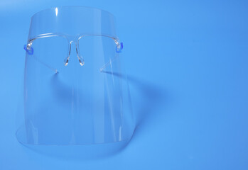 A picture of face shield on blue background. Face shield is needed and advised to wear during Covid-19 outbreak