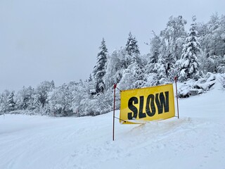 Slow Down yellow sign at ski slopes in Vermont