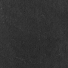 Cardboard black abstract texture close-up. Dark old paper background. Grunge concrete wall. Vintage blank wallpaper.