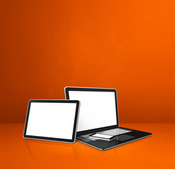 Laptop, mobile phone and digital tablet pc on orange office desk