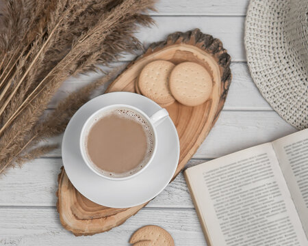 Flat lay with cup of espresso on wooden slice with cookies and book. Top view