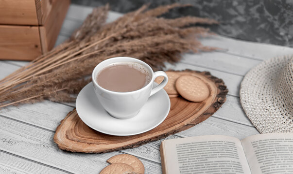 A cup of americano or espresso with biscuits, book nd reeds. Top view