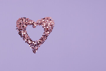 Heart shaped frame made of shiny sequins on a blue background. Festive texture for Valentines Day, Mothers Day, Womens Day, day of the wedding and Birthday. Banner, Flatlay, copy space.
