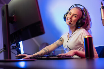 Smiling e-sport gamer girl vlogging and plays online video game on PC © kjekol