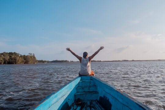 silueta de persona sentada en la punta de una lancha