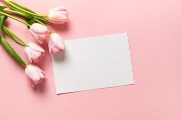 Pink tulips and empty blank sheets for cheers on pastel pink background. Top view with copy space. Greeting card for Mother Day.