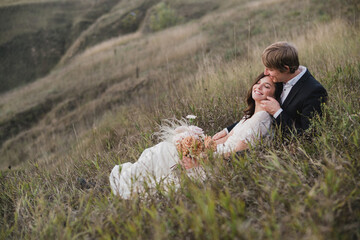 Romantic, young and happy caucasian couple in wedding clothes on the background of beautiful nature. Love, relationships, romance, happiness concept. Bride and groom traveling  together.