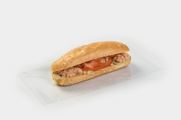 baguette with chopped chicken, tomatoes and herbs on a light background