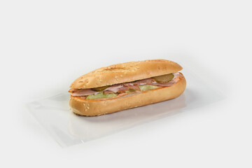 Baguette stuffed with chicken vegetables and cheese on a gray background