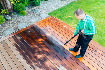 power washing - man cleaning terrace with a power washer - high water pressure cleaner on terrace surface