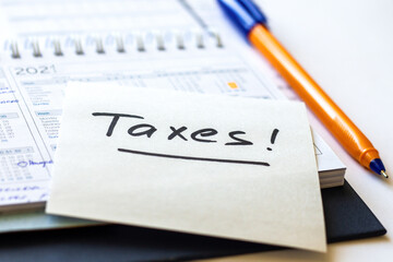 USA tax due date 17 April, a word Taxes written by marker on paper closeup