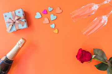Orange background, with roses, hearts, champagne glasses, champagne, copy space