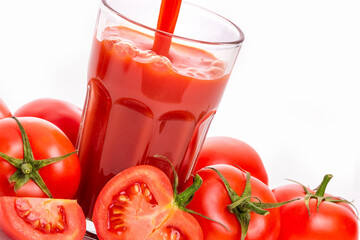Tomato juice in a glass and tomatoes with green sepals. isolate on white background