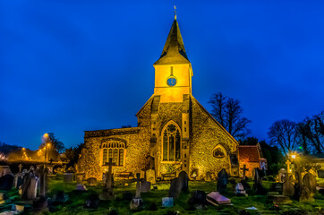 Naklejka premium A medieval church highlighted against the night sky in Sanderstead, Croydon, UK in winter