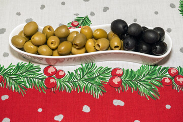 a plate of olives on a New Year's tablecloth