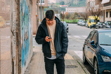 Fototapeta na wymiar teenage boy walking in the city looking at the mobile phone