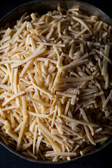 Bowl of traditional Turkish noodle (raw) on dark background. Turkish style domestic hand made noodle (eriste) on wooden background.