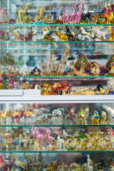 Glass window display shelf with dozens of colorful ceramic and glass souvenirs in Kusadasi, Turkey