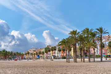 Villajoyosa sandy beach with coloful houses and palm trees. Spain