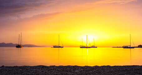 Beautiful sunrise on the Aegean Sea. Boats in ancient bay of Datca Peninsula.