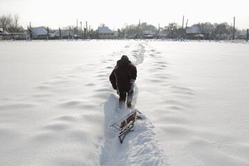 
a boy with a sled in the snow