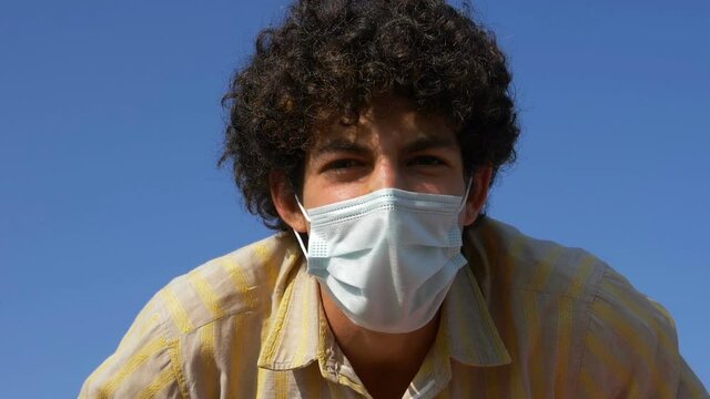 being tired of wearing the mask -young man tears off his mask and throws it away