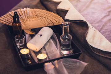 Massage set on the bed with aromatic oil and candles at the spa