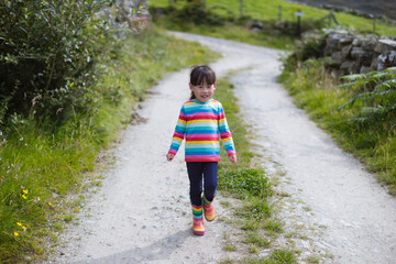 young  girl walking  on  summer countryside road