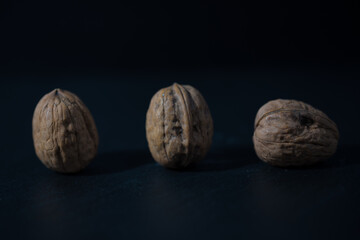 3 einsame Walnüsse auf einer Schieferplatte