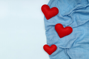 Layout with red hearts sewn from felt on blue fabric with space for text. The concept of Valentine's day.