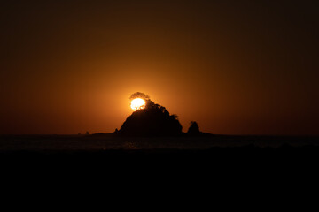 Fototapeta na wymiar Sunset behind the tree over the island 