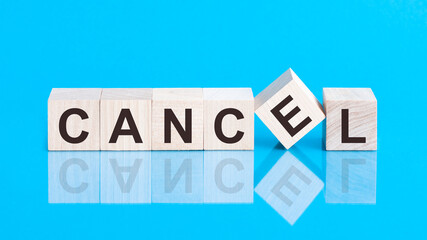 concept word forming with cube on wooden desk background - Cancel. Blue background.