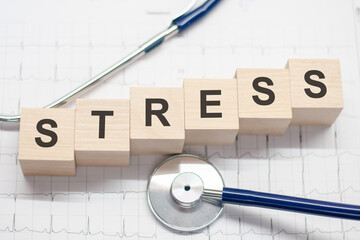 Stress word written on wooden blocks and stethoscope on light white background