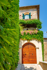 Beautiful old house with wall covered with green ivy in Umbria (Italy)
