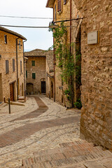 Fototapeta na wymiar Narrow alleys and ancient medieval buildings in the picturesque town of Spello, in Umbria (Italy)