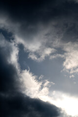 Die Sonne scheint nach einem Sturm in zwischen dunklen Wolken hindurch und erhellt den Himmel