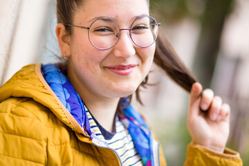 Cute girl with eyeglasses and with face skin problems. Outdoor photo