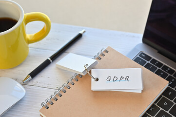 There's a word book on a desk cluttered with papers. The word GDPR is written in it. It's an...