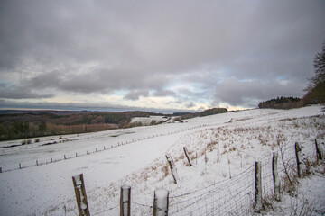 View from top of Michelsberg with white snow down to green valley at Eifel