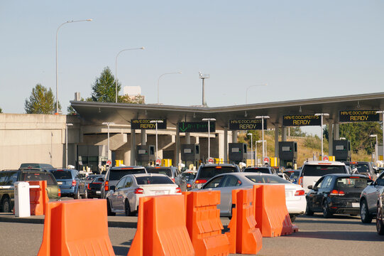 Cars Waiting At The Border Between Canada And The United States. Hot Day, Hot Air Waves Over Hot Cars.