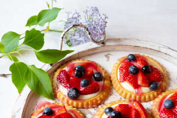 An Antique Tray With Strawberry And Blueberry Tarts