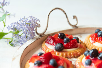 An Antique Tray With Strawberry And Blueberry Tarts
