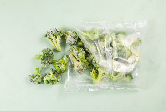 Frozen vegetables on light background with copy space. Broccoli in transparent bag. Proper defrosting of vegetables. Stock up on vitamins for winter