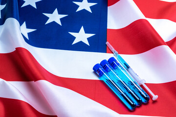 Usa Protection disease. Medical syringe with needle for protection flu virus and coronavirus. Covid vaccine on american flag background. Nurse or doctor. Liquid drug or narcotic.