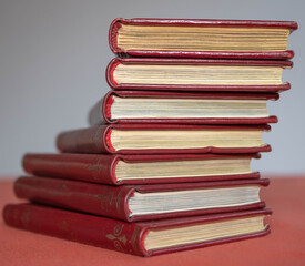 Stack of books with red leather covers and golden binding
